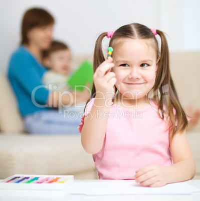 Little girl is playing with plasticine