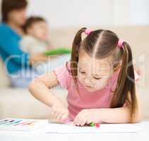 Little girl is playing with plasticine