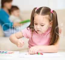 Little girl is playing with plasticine