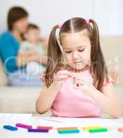 Little girl is playing with plasticine