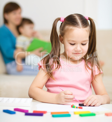 Little girl is playing with plasticine