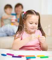 Little girl is playing with plasticine