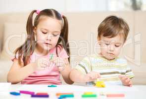 Sister and brother are playing with plasticine