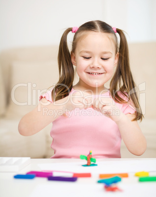 Little girl is playing with plasticine