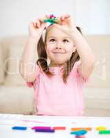 Little girl is playing with plasticine