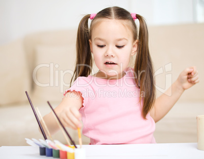 Cute cheerful child play with paints