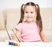 Cute cheerful child play with paints