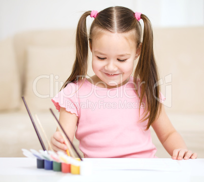 Cute cheerful child play with paints