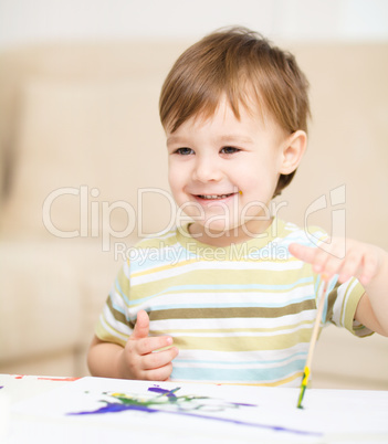 Little boy is playing with paints