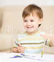 Little boy is playing with paints