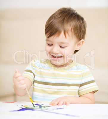 Little boy is playing with paints