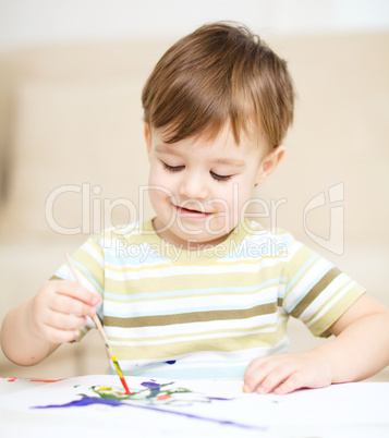 Little boy is playing with paints