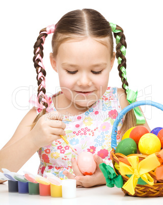 Little girl is painting eggs preparing for Easter