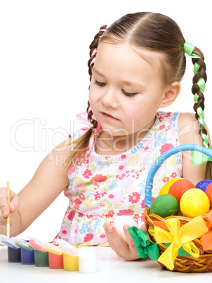 Little girl is painting eggs preparing for Easter