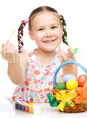 Little girl preparing eggs for Easter