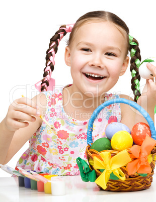 Little girl preparing eggs for Easter