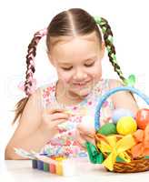 Little girl preparing eggs for Easter