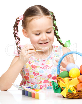 Little girl preparing eggs for Easter