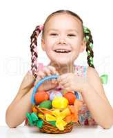 Little girl with basket full of colorful eggs