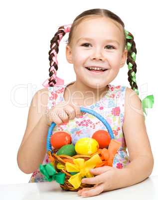 Little girl with basket full of colorful eggs