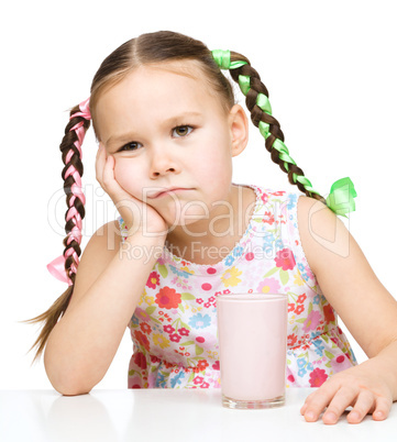 Gloomy little girl doesn't want to drink milk