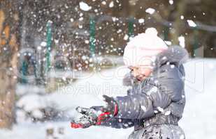 Little girl is throwing snow