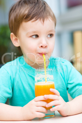 Little boy with glass of orange juice