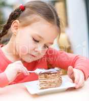 Little girl is eating cake in parlor