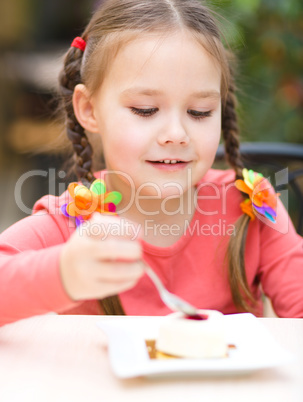 Little girl is eating cake in parlor