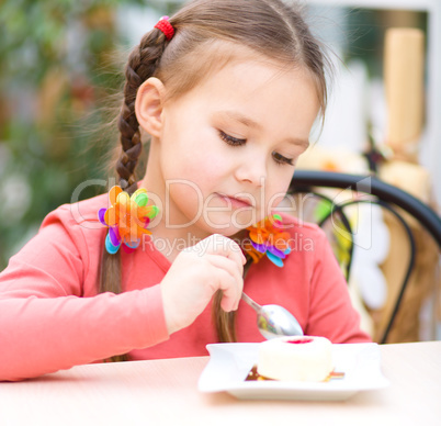 Little girl is eating cake in parlor