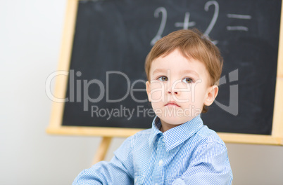Little boy is sitting on math lesson