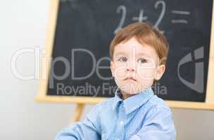Little boy is sitting on math lesson