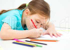 Little girl is drawing using pencils