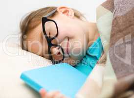 Girl is sleeping with her book and glasses