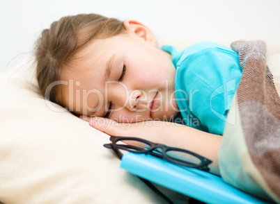 Girl is sleeping with her book and glasses