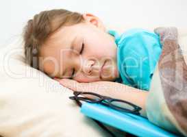 Girl is sleeping with her book and glasses