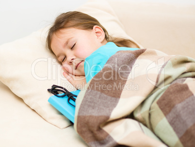 Girl is sleeping with her book and glasses