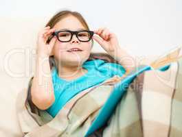 Little girl is reading a book