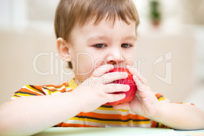 Little boy is eating apple