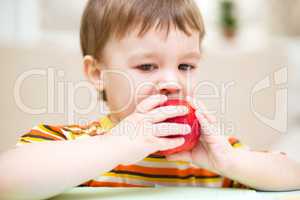 Little boy is eating apple