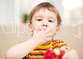 Little boy is eating apple