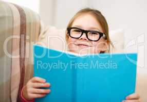 Little girl is reading a book