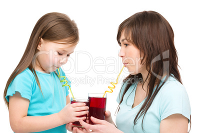 Mother and her daughter are drinking juice