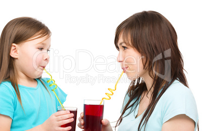 Mother and her daughter are drinking juice