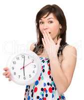 Young woman is holding big clock