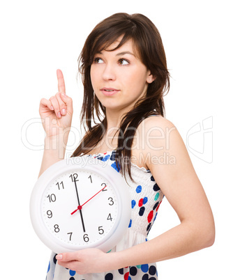 Young woman is holding big clock