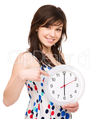 Young woman is holding big clock