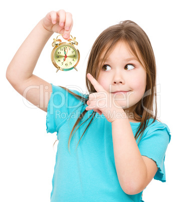 Little girl is holding small alarm clock