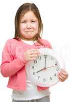 Little girl is holding big clock