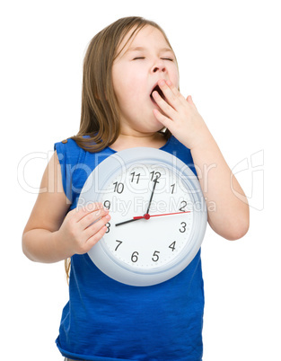 Little girl is holding big clock